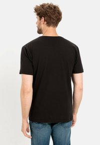 Zwarte t-shirt met korte mouwen van katoen, met een klassiek rond halsontwerp, een effen kleur en minimale stikseldetails.