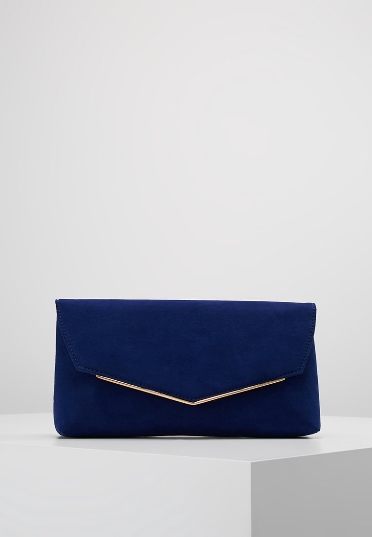 Clutch de ante azul marino con una solapa triangular y acento en metal dorado. Textura suave, forma rectangular, diseño minimalista.