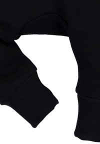 Zwarte sweatshirt detail met ribbelmanchetten en een gladde, zachte textuur. De stof lijkt dik met een klassiek afgerond ontwerp.