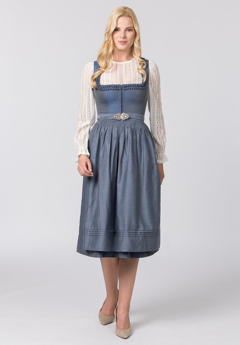 Traditionelles blaues Dirndl mit tailliertem Mieder, voluminösem Rock und weißer Spitzenbluse. Verziert mit dekorativen silbernen Knöpfen und strukturiertem Stoff.