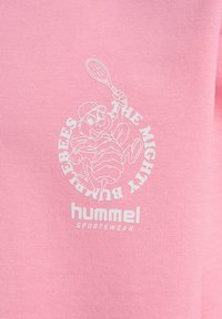 Rosa bomull t-shirt med en vit grafisk design av en tecknad bi som håller en tennisracket, med texten "THE MIGHTY BUZZBEES" och "hummel SPORTSWEAR".
