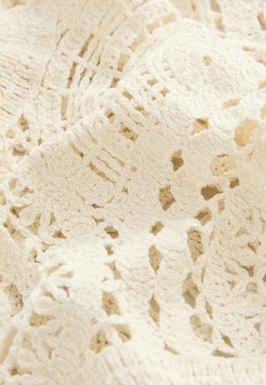 Häkelspitzenstoff in Off-White mit intricaten Blumen- und geometrischen Mustern; weiche Textur und leichtes Erscheinungsbild.