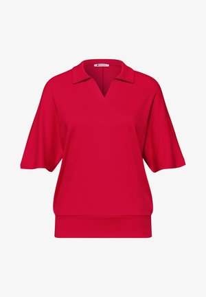 Polo rouge à manches courtes avec un large col et un ourlet côtelé, présenté sur fond blanc.