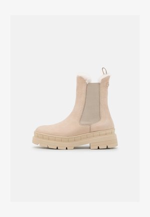 Beige Knöchelschuhe mit Obermaterial aus Wildleder, elastischen seitlichen Einsätzen, flauschigem Kragenrand und einer dicken Gummisohle mit strukturierter Oberfläche.