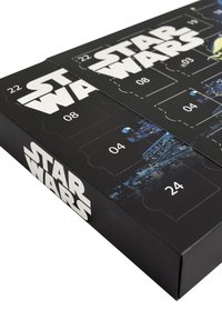 Calendario dell'avvento a tema Star Wars con design a scatola nera, dotato di linguette numerate, superficie lucida e grafiche di sfondo stellato.
