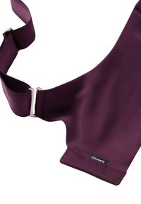 Syvän violetin säädettävä kangasranneke metallisella liukusäätimellä ja pienellä mustalla tunnuksella, jossa lukee "Closely", yksinkertaisella valkoisella taustalla.