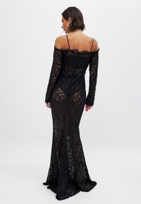 Must mustertavaga musterdest ja õlgadest eemal olev kaelus. Omab vormitud siluetti ja peeneid säravaid detaile.