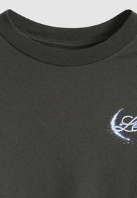 Camiseta de algodão verde escuro com decote redondo e um desenho gráfico azul com uma lua crescente e estrelas no peito.