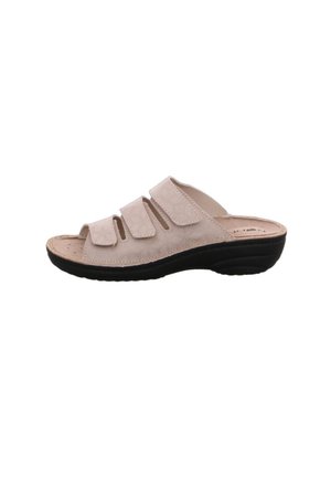 Beige slippers met drie verstelbare klittenbandsluitingen, gestructureerde bovenkant, open teengedeelte en een gevoerde zwarte rubberen zool.