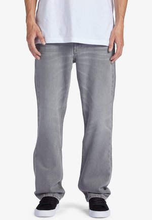 Gray denim jeans with a straight-leg fit, featuring subtle whiskering and a classic five-pocket design. Worn with black sneakers.