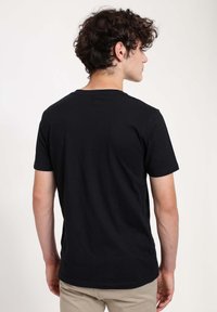Czarny t-shirt z krótkim rękawem wykonany z bawełny, z okrągłym dekoltem i prostym dołem. Gładka tekstura bez widocznego logo lub wzorów.