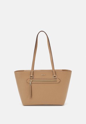 Beige tote bag with two shoulder straps, featuring a zip pocket on the front. Smooth texture and logo displayed prominently at the center.
