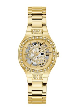 Gold watch with a skeleton design, crystal accents around the bezel, and a gold-tone bracelet. Features a white dial with black detailing.