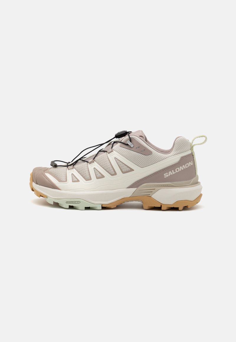 Leichte Trail-Schuhe mit einem beige-grauen Mesh-Obermaterial, schwarzen Schnürsenkeln und einer flexiblen Gummisohle in Beige und Mintgrün. Dezente Markenkennzeichnung vorhanden.