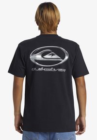 Black cotton t-shirt featuring a large silver logo on the back, short sleeves, and a relaxed fit. Simple design with no additional patterns.