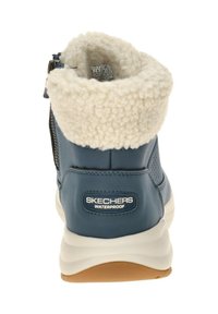 Waterproof blauwe leren laars met een pluche witte fleece voering bij de kraag, gevoerde zool en een merklabel op de hak. Detail met zijrits.