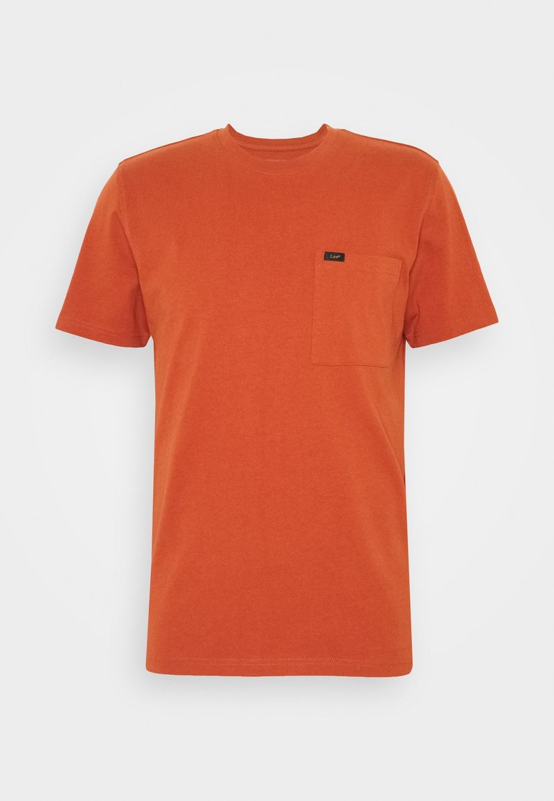 T-shirt en coton orange avec un col ras du cou, des manches courtes et une poche sur la poitrine gauche comportant une petite étiquette noire. Texture lisse.