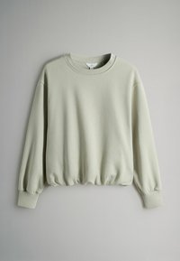 Vaaleanvihreä collegepaita, joka on valmistettu pehmeästä kankaasta. Siinä on pyöreä pääntie, lasketut hartiat ja kerätty helma elastisella resorilla.