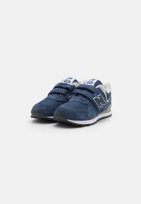 Chaussures de sport bleu marine en mélange de maille et de suède, avec deux sangles Velcro, des accents blancs et une semelle texturée.