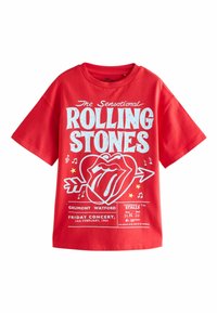 Červené bavlnené tričko s veľkým modrým potlačeným dizajnom obsahujúcim logo Rolling Stones, podrobnosti o koncerte, hudobné noty a hviezdy. Krátke rukávy.