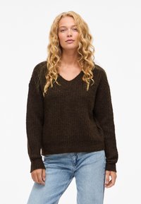 Maglione marrone a maglia con scollo a V, maniche lunghe e vestibilità comoda. Tessuto strutturato con polsini a coste e orlo leggermente corto.