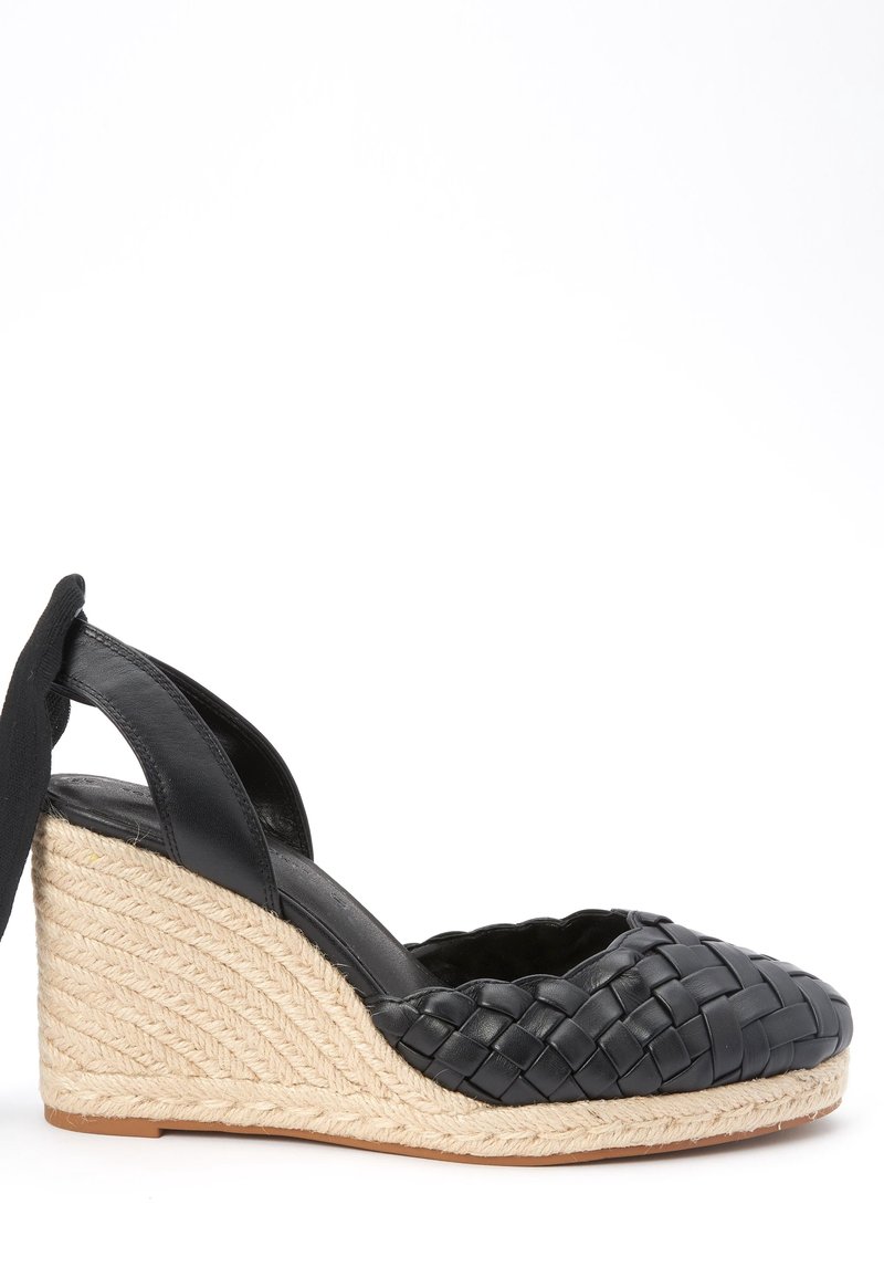 Sandale compensée en cuir tressé noir avec une plateforme recouverte de jute. Comprend un dos ouvert et une doublure intérieure lisse pour le confort.