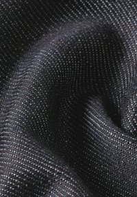 Tela negra texturada con un tejido fino, que presenta sutiles puntos de luz. El material parece suave y flexible, creando pliegues suaves.