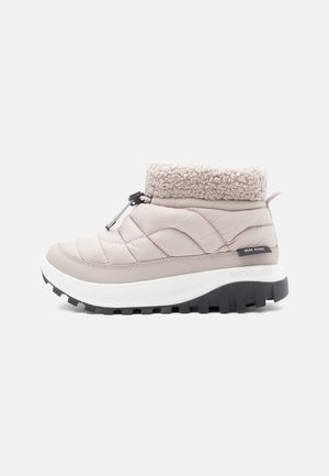 Beige quilted ankle boots with a fluffy collar, white midsole, and black rubber outsole featuring multi-directional treads.