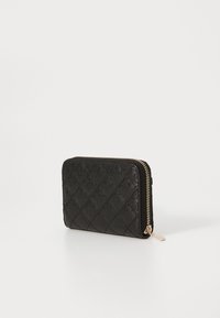 Portefeuille noir matelassé en matériau synthétique texturé, doté d'une fermeture éclair dorée et de motifs de logo en relief sur la surface.