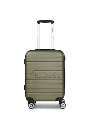Olive green hard-shell suitcase with vertical grooves, white telescopic handle, and four wheels. Features embossed "Bench" logo on the front.