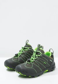 Mustat ja vihreät vaelluskengät, joissa on kumipohja, verkkopaneelit ja joustavat nauhat. Varustettu pehmustetulla nilkkasaumalla ja erottuvalla ompeleella.