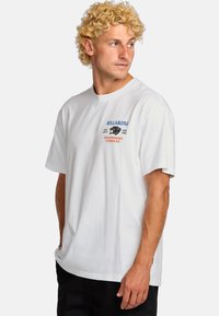 Witte katoenen t-shirt met een ronde hals, korte mouwen en voorop logo graphics in blauw en oranje. Casual pasvorm met zijnaad.