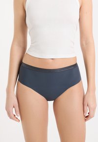 Sous-vêtements taille haute bleu foncé avec une finition lisse et une ceinture grise métallique. Confectionnés dans un matériau extensible et sans coutures.