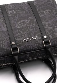 Zwarte tas met een gestructureerd reisstempelpatter. Voorzien van leren banden, zilveren hardware en een opvallend logo aan de voorkant. Met ritssluiting.