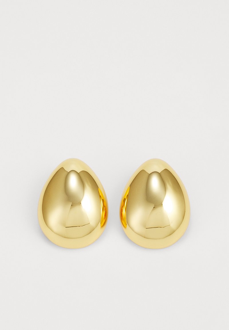 Boucles d'oreilles clous de couleur or avec une surface lisse et polie, en forme de goutte d'eau, réfléchissant la lumière pour un fini éclatant.