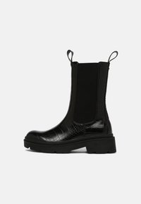 Black ankle boots with a crocodile texture, elastic side panels, and pull tabs, featuring a chunky sole for added height and grip.
