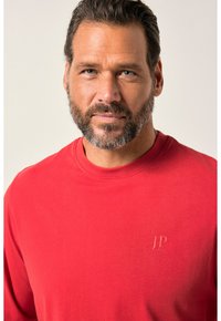 Rode sweatshirt met een ronde hals, gemaakt van zacht materiaal. Heeft een subtiele reliëf logo "JP" op de linkerkant van de borst. Minimalistisch ontwerp.