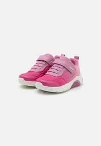 Lätta rosa sneakers med nätöverdel, elastiska snören, ett kardborreband och en vit gummisula med ett texturerat mönster.