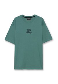Camiseta gráfica de algodón en color teal apagado con mangas cortas y cuello redondo. El texto en negro dice: "¡Grandes cosas vienen!" en la parte delantera.