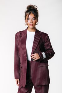 Burgundský pruhovaný blazer s přiléhavým střihem, s klopovými límci, dvěma předními kapsami a bílým štítkem na manžetě.