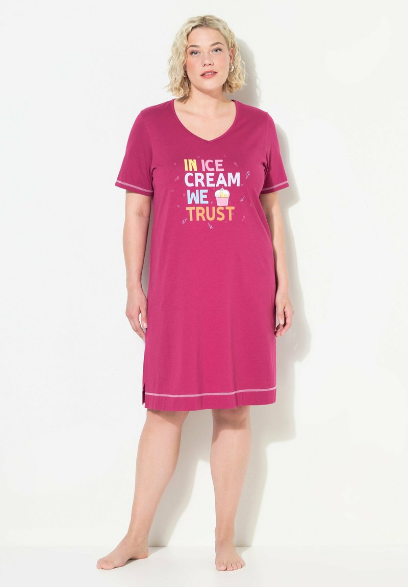 Camicia da notte rosa con scollatura a V e maniche corte. Presenta una stampa grafica con la scritta "IN ICE CREAM WE TRUST" e spacchi laterali. Materiale in cotone morbido.