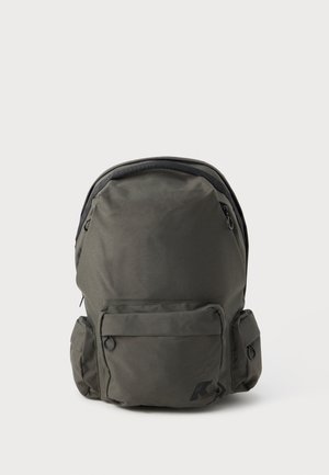 Dunkelgrüner Rucksack aus strapazierfähigem Stoff in runder Form, mit zwei Seitentaschen, einem oberen Griff und einer Vorderseite mit Reißverschluss.