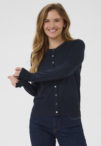 Cardigan bleumarin cu guler rotund, mâneci lungi �și textura ribbată; prezintă nasturi metalici pe față. Croi lejer.