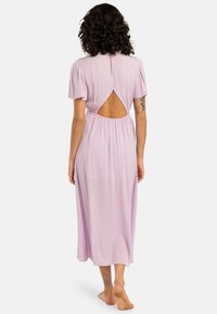 Lilac dress with a back cutout, short puff sleeves, and a gathered waist. Made of lightweight fabric, falls to mid-calf with soft texture.