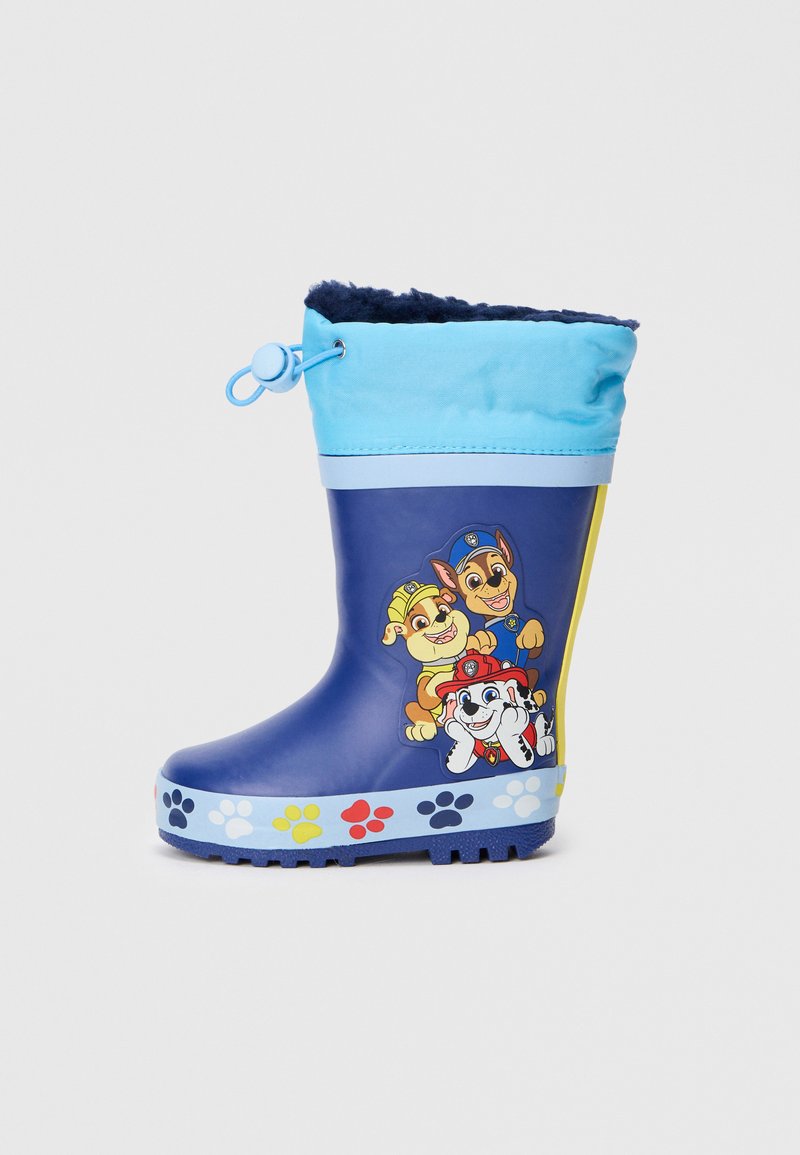 Bota de lluvia de goma en color navy con la parte superior en azul claro, que presenta tres personajes de perros animados y un patrón de huellas de patas coloridas alrededor de la base.