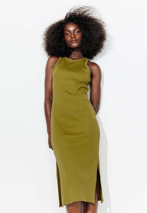 Robe midi vert olive avec un design sans manches, texture côtelée et fentes latérales pour plus de liberté de mouvement. Tissu lisse, silhouette près du corps.