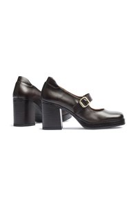 Zapatos Mary Jane de cuero marrón con punta redondeada, costados bajos y una hebilla dorada. Presentan un tacón grueso apilado y una suela texturizada.