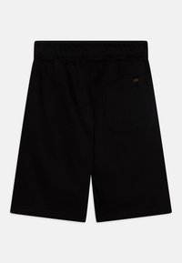 Black cotton shorts with an elastic waistband, featuring a back pocket and a small branded label on the right rear.