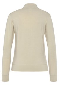 Šviesiai kreminė ilgomis rankovėmis polo marškinėliai su apykakle ir rausvais manžetais. Lygus paviršius, minimalus dizainas, be matomų logotipų ar raštų.