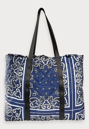 Grand sac cabas matelassé bleu marine avec motifs paisley et floraux blancs et anses noires.
